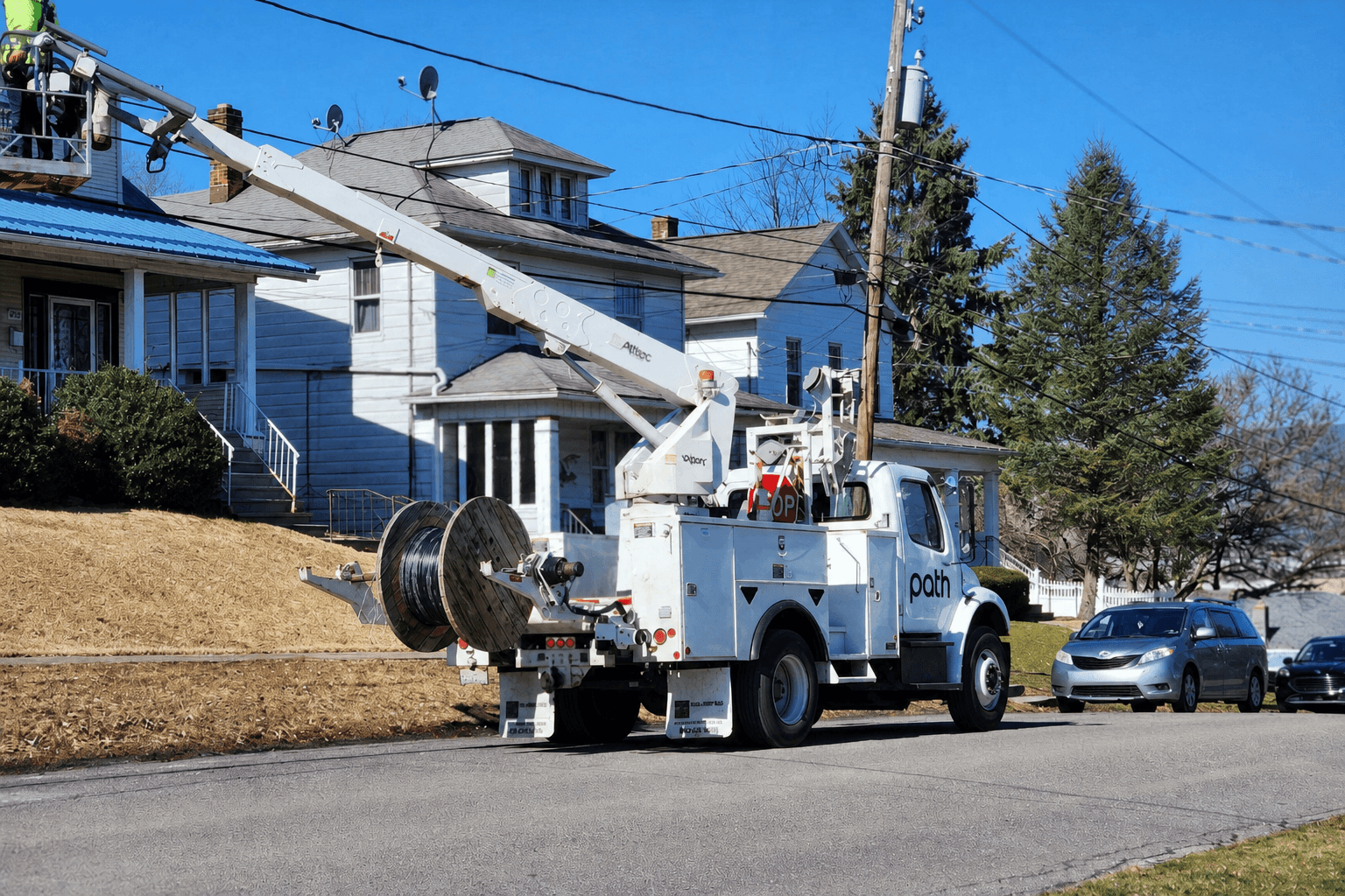 A Path bucket truck running aerial fiber on a residential street
